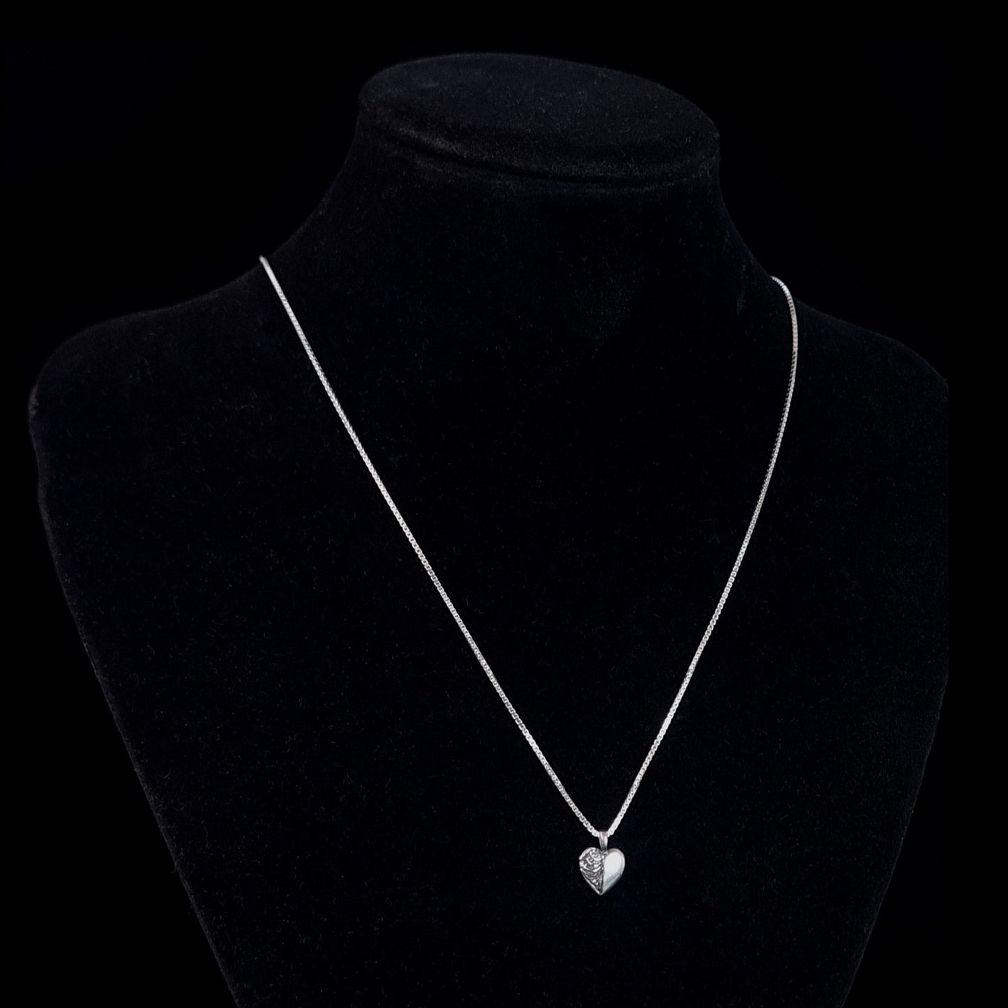 Sterling silver Ribcage Heart pendant by RBZ Jewelry displayed on a black mannequin bust, showing the anatomical gothic necklace's scale on a silver box chain.