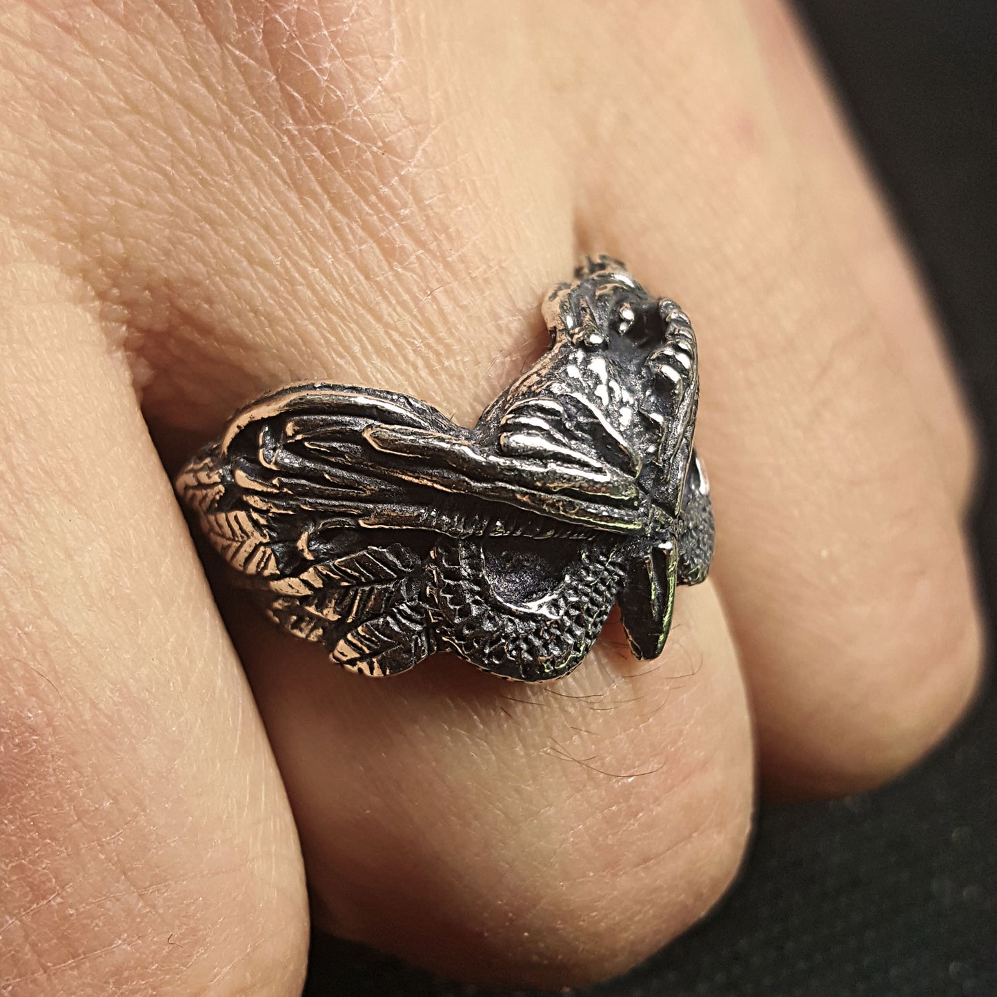 Lifestyle shot of the sterling silver Night Owl ring worn on a person's finger, showing its fit and statement appearance