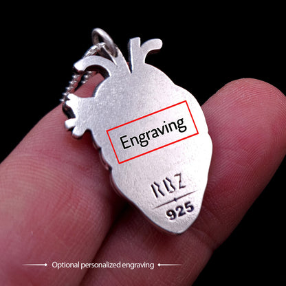 The back view of the sterling silver anatomical heart pendant by RBZ Jewelry, held between fingers to show scale, highlighting the dedicated space for optional personalized laser engraving alongside the "RBZ" logo and "925" silver hallmark.