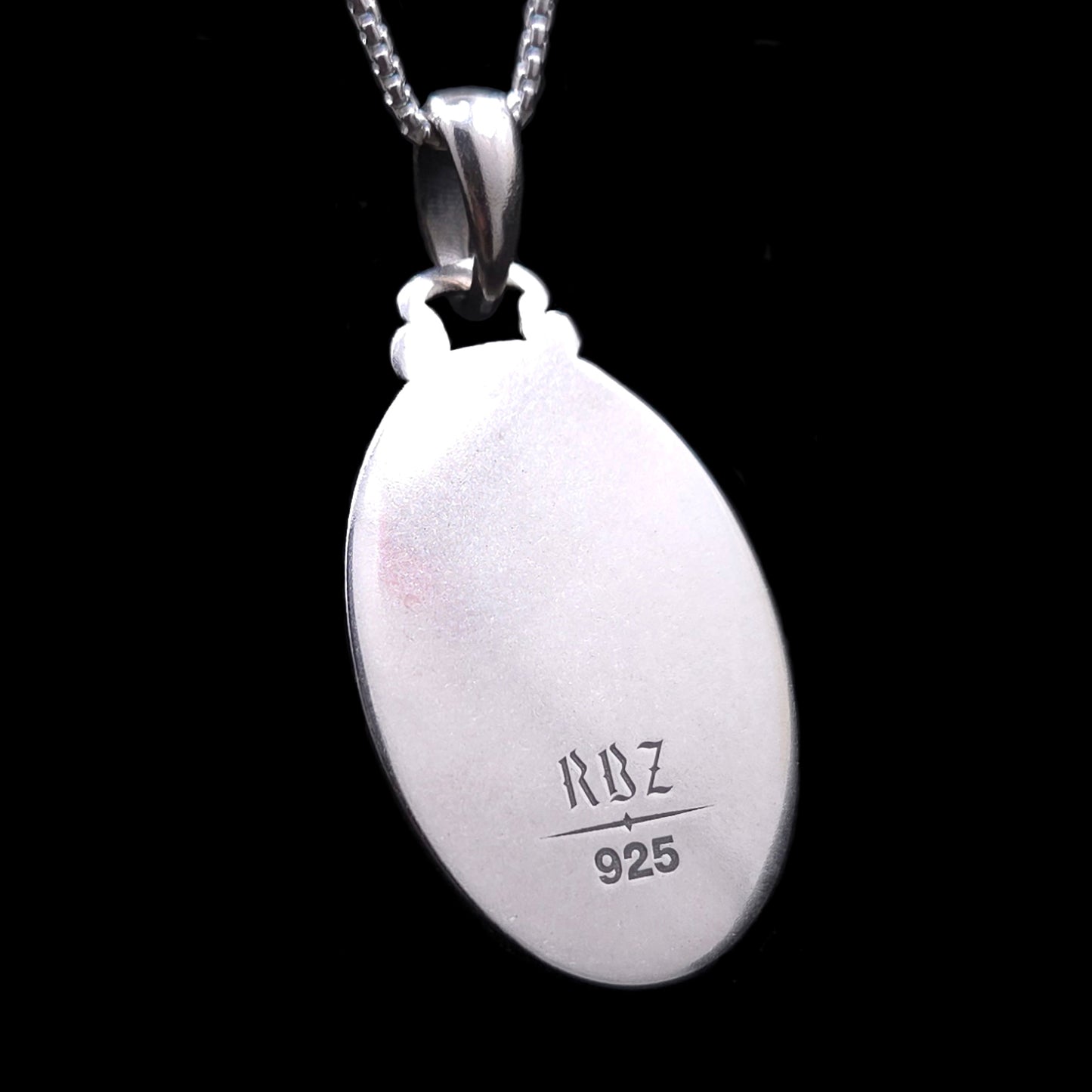 Reverse side of the oval, Gothic Judaica sterling silver Chai pendant, showing a highly polished, engravable surface. Engraved at the bottom are the maker's mark 'RBZ' and the '925' silver hallmark.