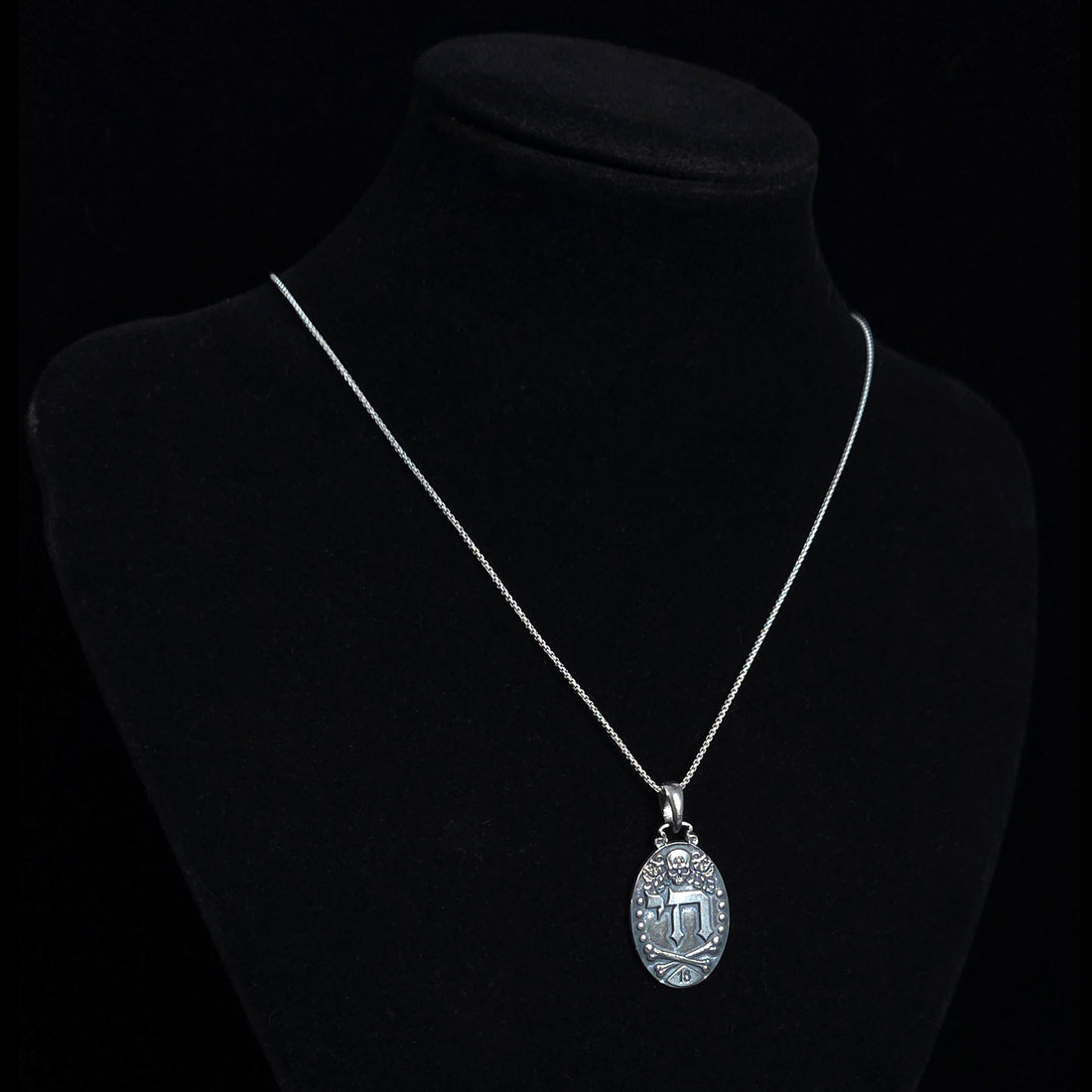 Gothic Judaica sterling silver Chai pendant by RBZ Jewelry, displayed on a silver chain around a black mannequin display bust to show necklace drop length.