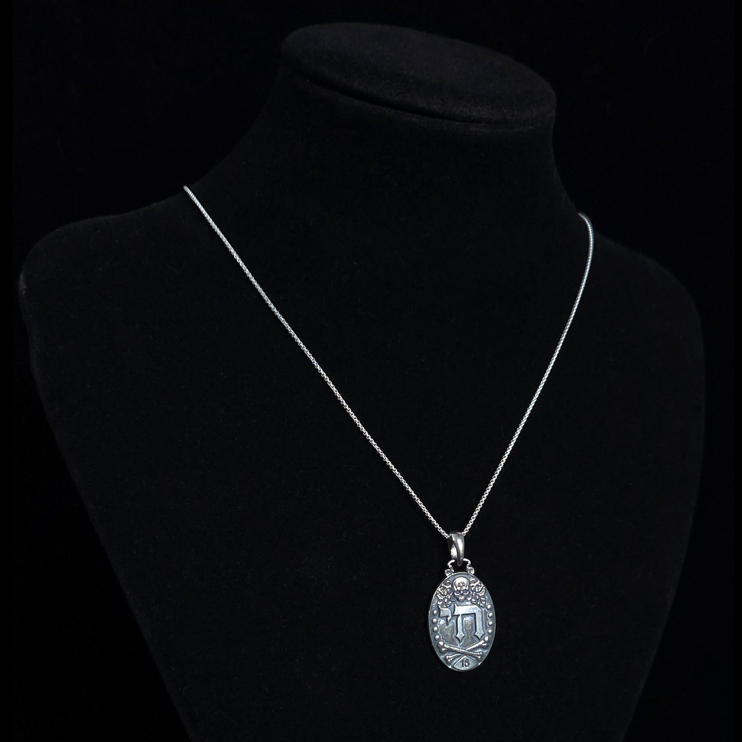 Gothic Judaica sterling silver Chai pendant by RBZ Jewelry, displayed on a silver chain around a black mannequin display bust to show necklace drop length.