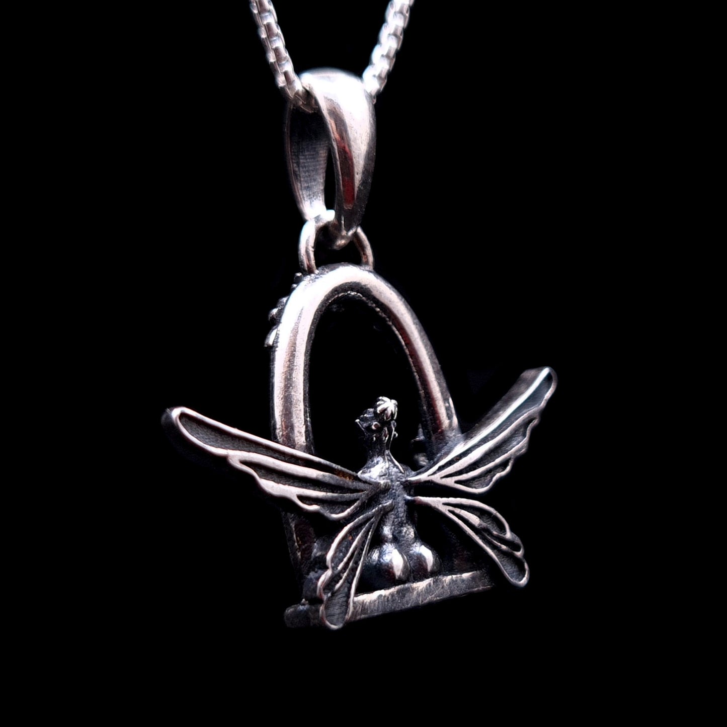 Back view of the sterling silver Flower Fairy pendant by RBZ Jewelry, showing the sprawling span of the fairy’s detailed wings and the back of her garden swing seat.