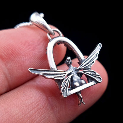Back view of the sterling silver Flower Fairy pendant by RBZ Jewelry held in hand, showing the intricate details of the fairy’s wings and the reverse side of the floral swing seat.