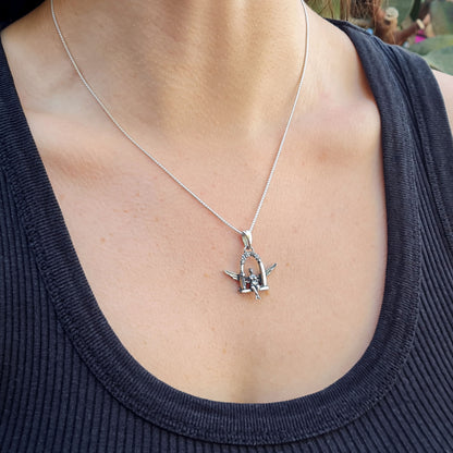 Lifestyle shot of a female model wearing the sterling silver Flower Fairy pendant by RBZ Jewelry on a thin silver chain, showcasing the scale and gothic-fantasy aesthetic of the piece when worn.