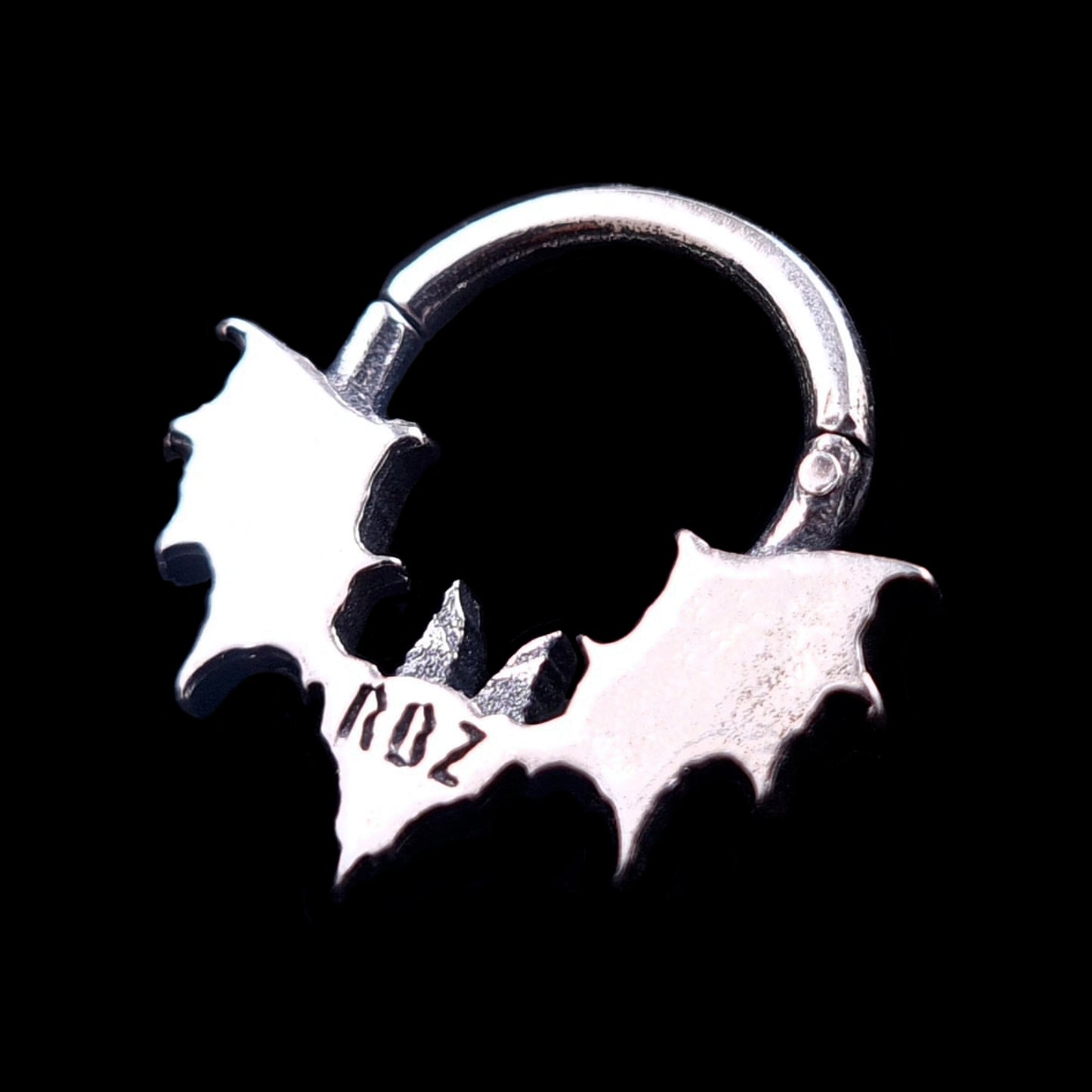 Reverse view of the Gothic Sterling Silver Glitched Bat septum ring by RBZ Jewelry, showing the smooth back of the bat and featuring a clearly engraved hallmark "RBZ". Set against a black background.