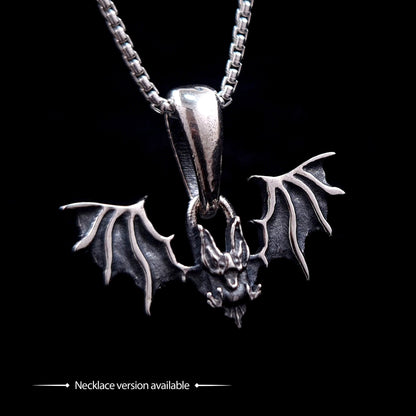 Gothic Sterling silver Glitched Bat pendant necklace by RBZ Jewelry, featuring a visceral, distorted bat silhouette with textured spread wings on a silver box chain. The image includes text at the bottom stating "Necklace version available," set against a solid black background.