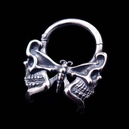 Sterling silver Gothic butterfly skull septum clicker ring by RBZ Jewelry, featuring intricately carved human skull wings and a polished finish on a black background.