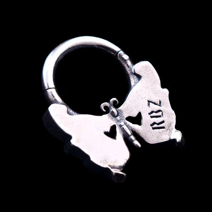 Back view of the Sterling silver butterfly skull septum clicker ring by RBZ Jewelry, showing the smooth reverse side of the wings with an RBZ logo engraving.