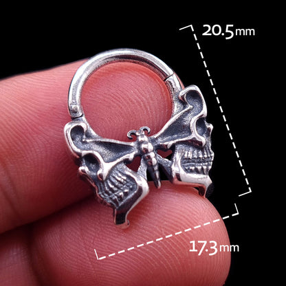Sterling silver Gothic butterfly skull septum clicker ring by RBZ Jewelry, held in hand with dimension markings showing its height of 20.5mm and width of 17.3mm.