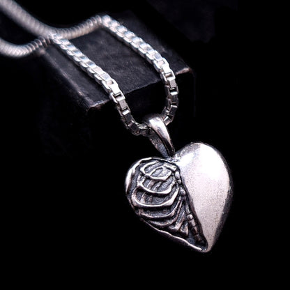 RBZ Jewelry sterling silver Gothic Ribcage Heart pendant featuring a mirror-polished smooth side transitioning into a detailed, oxidized anatomical ribcage on a silver box chain.