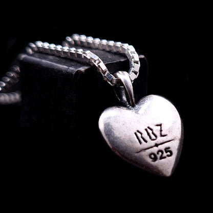 The back side of the RBZ Jewelry Gothic Ribcage Heart pendant in sterling silver, featuring an engraved RBZ logo and 925 hallmark on a polished surface.