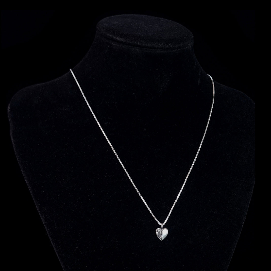 Sterling silver Ribcage Heart pendant by RBZ Jewelry displayed on a black mannequin bust, showing the anatomical gothic necklace's scale on a silver box chain.