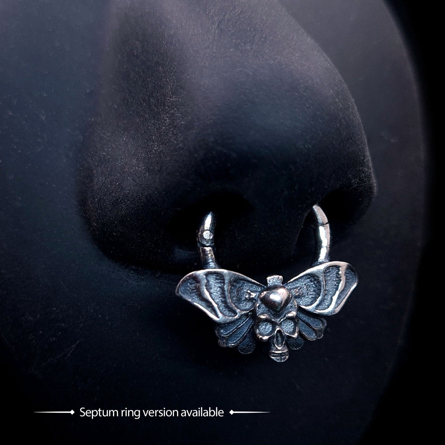 Gothic Death Moth skull septum piercing ring, sterling silver, shown modeled on a practice nose. Bottom text reads: '➡ Septum ring version available ➡' by RBZ Jewelry