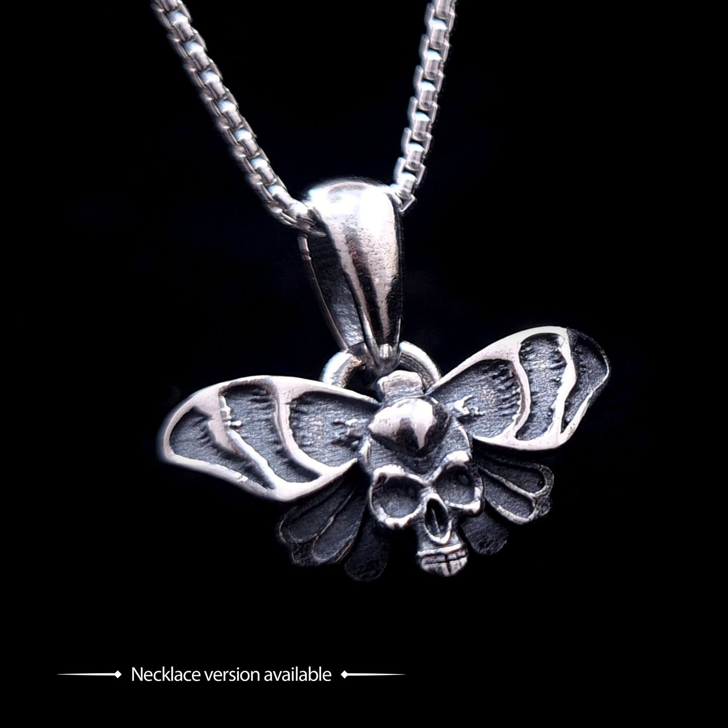 Sterling silver Gothic Death Moth pendant necklace, by RBZ Jewelry, featuring an intricate skull motif on the thorax and detailed spread wings, suspended from a silver chain against a black background.
