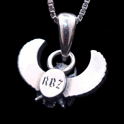 The reverse side of the sterling silver Gothic Egyptian Skull Scarab pendant by RBZ Jewelry, showcasing the back of the winged form on a solid black background. A central circular medallion features the distinct engraved brand logo 'RBZ' in a stylized font.