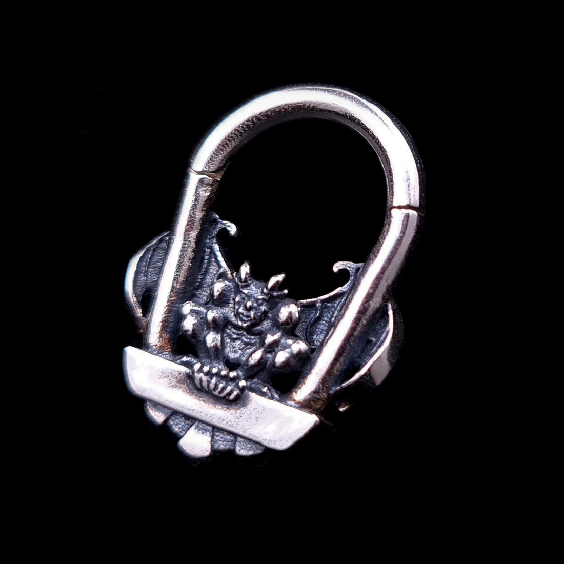 A detailed front view of the RBZ Jewelry Gargoyle Guardian septum ring, an intricately carved sterling silver clicker jewelry piece featuring a gothic gargoyle with spread wings and sharp claws, set against a solid black background.