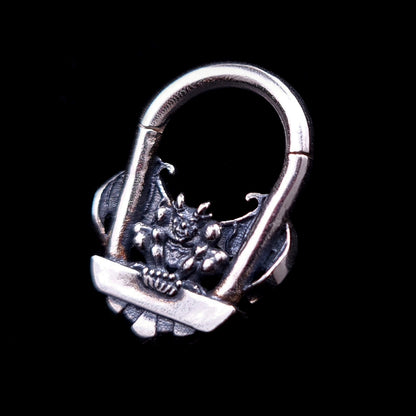 A detailed front view of the RBZ Jewelry Gargoyle Guardian septum ring, an intricately carved sterling silver clicker jewelry piece featuring a gothic gargoyle with spread wings and sharp claws, set against a solid black background.