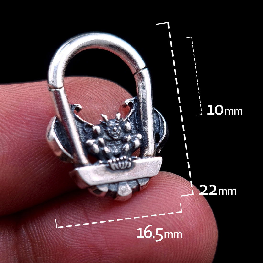 A front view of the RBZ Jewelry Gargoyle Guardian septum ring held between fingers, featuring white dimension overlays indicating a 10mm inner diameter, 22mm total height, and 16.5mm width. The sterling silver clicker showcases the detailed gothic gargoyle sculpture, providing a clear sense of scale for the wearable art piece.