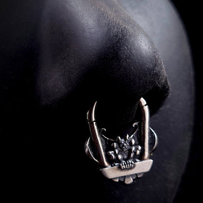 The RBZ Jewelry Gargoyle Guardian septum ring displayed on a life-size black silicone nose model, demonstrating the scale and visual impact of the detailed sterling silver gothic gargoyle design when worn in a septum piercing.