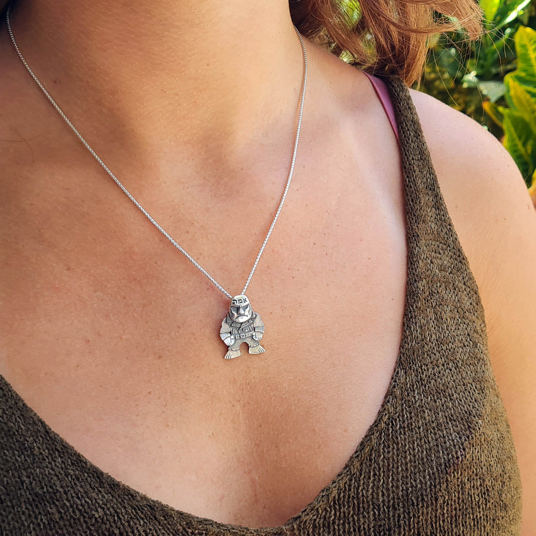 Lifestyle view of the sterling silver Golem of Prague pendant by RBZ Jewelry, worn by a female model. The punk-rock guardian pendant hangs from a delicate silver chain, showcasing its scale and gothic aesthetic as an everyday statement piece.