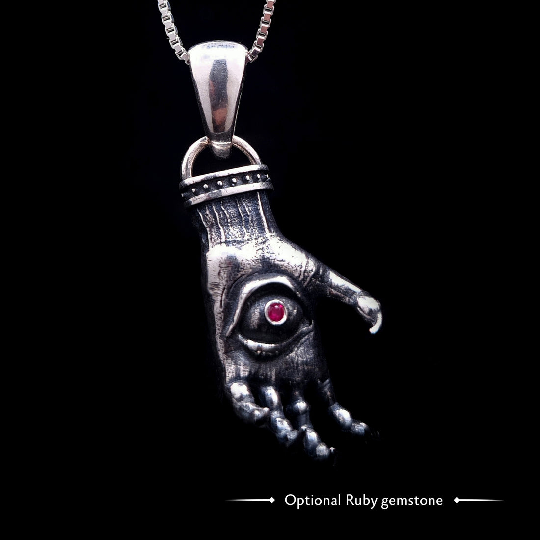 'The Nocturnal Hamsa' Sterling Silver Pendant by RBZ Jewelry - Gothic Hamsa with a creepy clawed hand design, featuring a pentagram ring and a central haunted eye with an optional ruby gemstone. The heavily oxidized silver piece hangs on a chain.