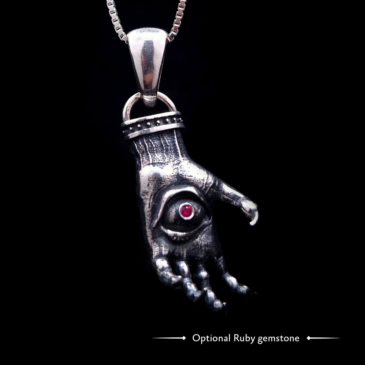 'The Nocturnal Hamsa' Sterling Silver Pendant by RBZ Jewelry - Gothic Hamsa with a creepy clawed hand design, featuring a pentagram ring and a central haunted eye with an optional ruby gemstone. The heavily oxidized silver piece hangs on a chain.