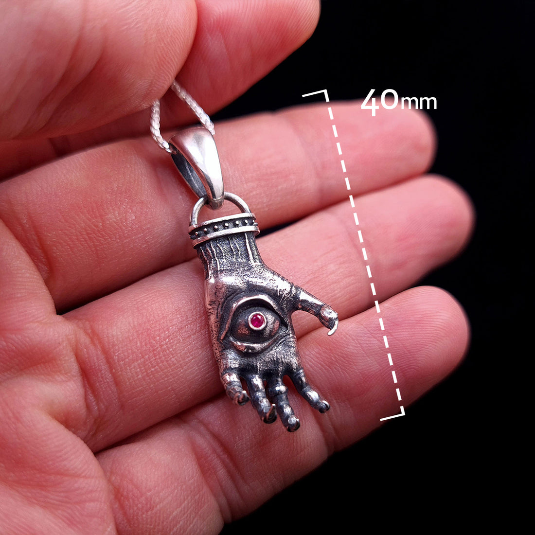 'The Nocturnal Hamsa' Sterling Silver Pendant Dimensions by RBZ Jewelry - Front view of gothic clawed hand with ruby gemstone eye, held in hand for scale with 40mm height indicator.