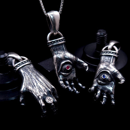 'The Nocturnal Hamsa' Sterling Silver Pendants Group Shot by RBZ Jewelry - Atmospheric display of three Gothic clawed hand designs featuring Ruby, Blue Sapphire, and a reversible back view with an intricate Pentagram ring.