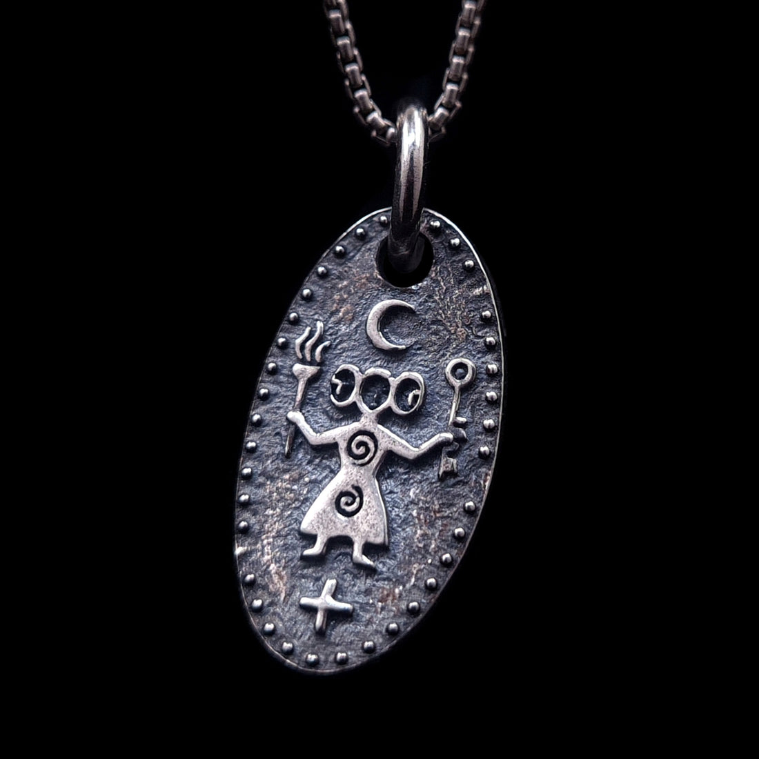 Front view of the Hecate, Greek triple goddess medallion in solid 925 sterling silver by RBZ Jewelry, featuring an oxidized ancient cave art style with torches, key, and crescent moon symbols