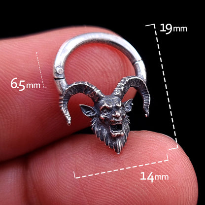 Front view of the sterling silver Horned Demon septum clicker ring by RBZ Jewelry held between fingers, featuring overlaid measurement graphics indicating a 19mm total height, 14mm overall width, and a 6.5mm inner wearable drop, set against a black background.