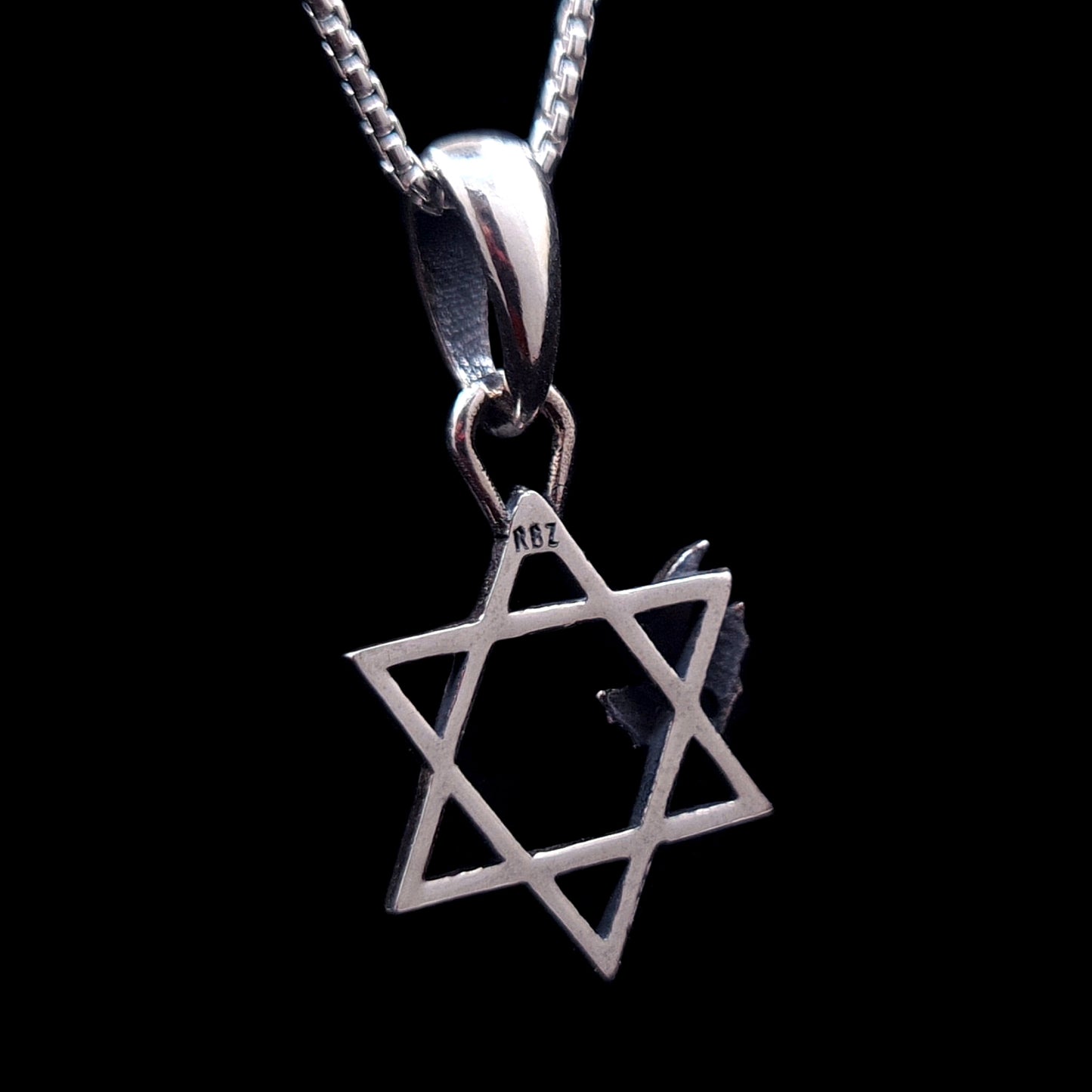 Back view of the sterling silver Bats Star of David pendant by RBZ Jewelry, showing the RBZ designer hallmark stamped on the top point of the Magen David, isolated on a black background.
