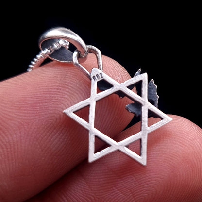 Back view of the sterling silver Bats Star of David pendant held between fingers for scale, showing the RBZ designer hallmark on the top point of the Magen David, by RBZ Jewelry.