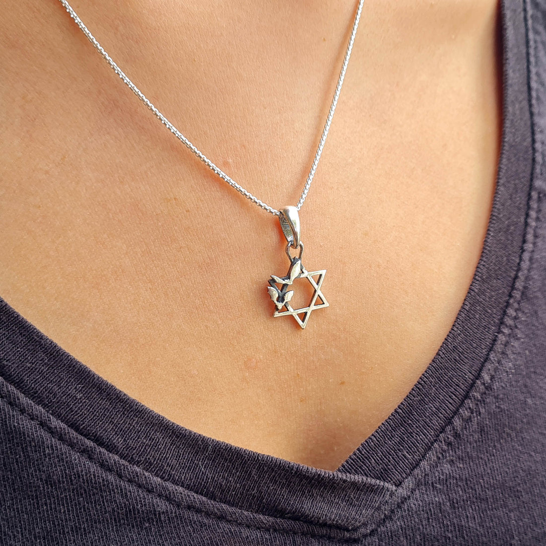 Sterling silver Bats Star of David pendant from the RBZ Jewelry Gothic Judaica collection, worn by a model on a silver chain to show length and placement.