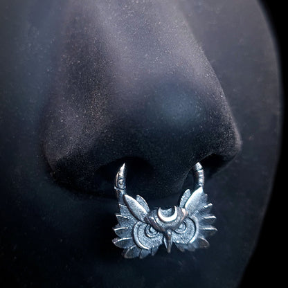 Sterling silver Moon Owl septum ring by RBZ Jewelry, shown worn on a life-size black silicone nose mannequin to demonstrate placement and scale. The handcrafted, gothic-style septum clicker features a detailed owl face and crescent moon with a dark oxidized finish.