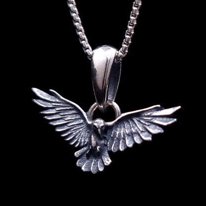 Sterling silver flying raven pendant with detailed textured feathers and spread wings, Gothic style dark crow necklace by RBZ Jewelry.