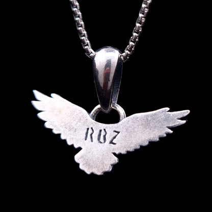 Back view of the sterling silver flying raven pendant featuring the RBZ brand engraving on the smooth reverse side, handcrafted Gothic crow necklace by RBZ Jewelry.