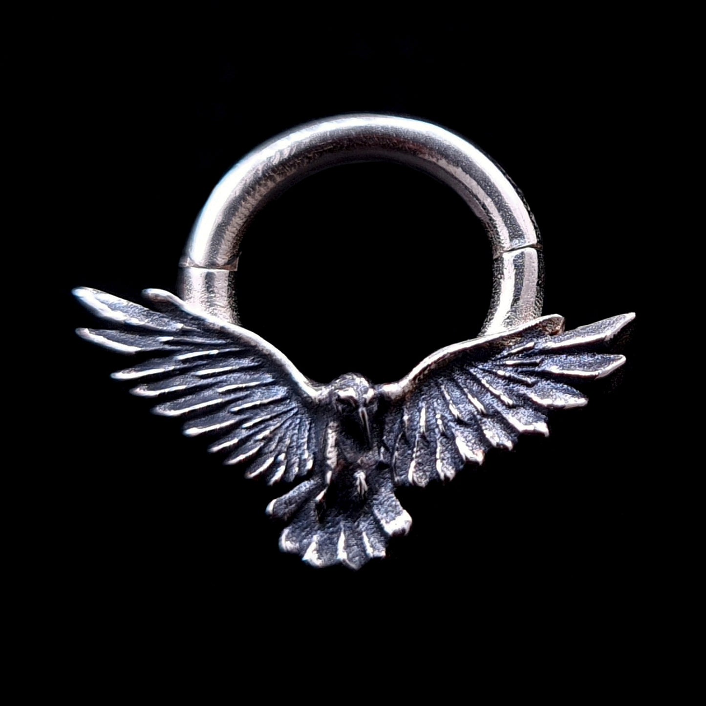 Sterling silver Dark Raven septum ring by RBZ Jewelry, featuring a detailed raven in mid-flight with wide outspread wings and an oxidized antique finish on a solid black background.