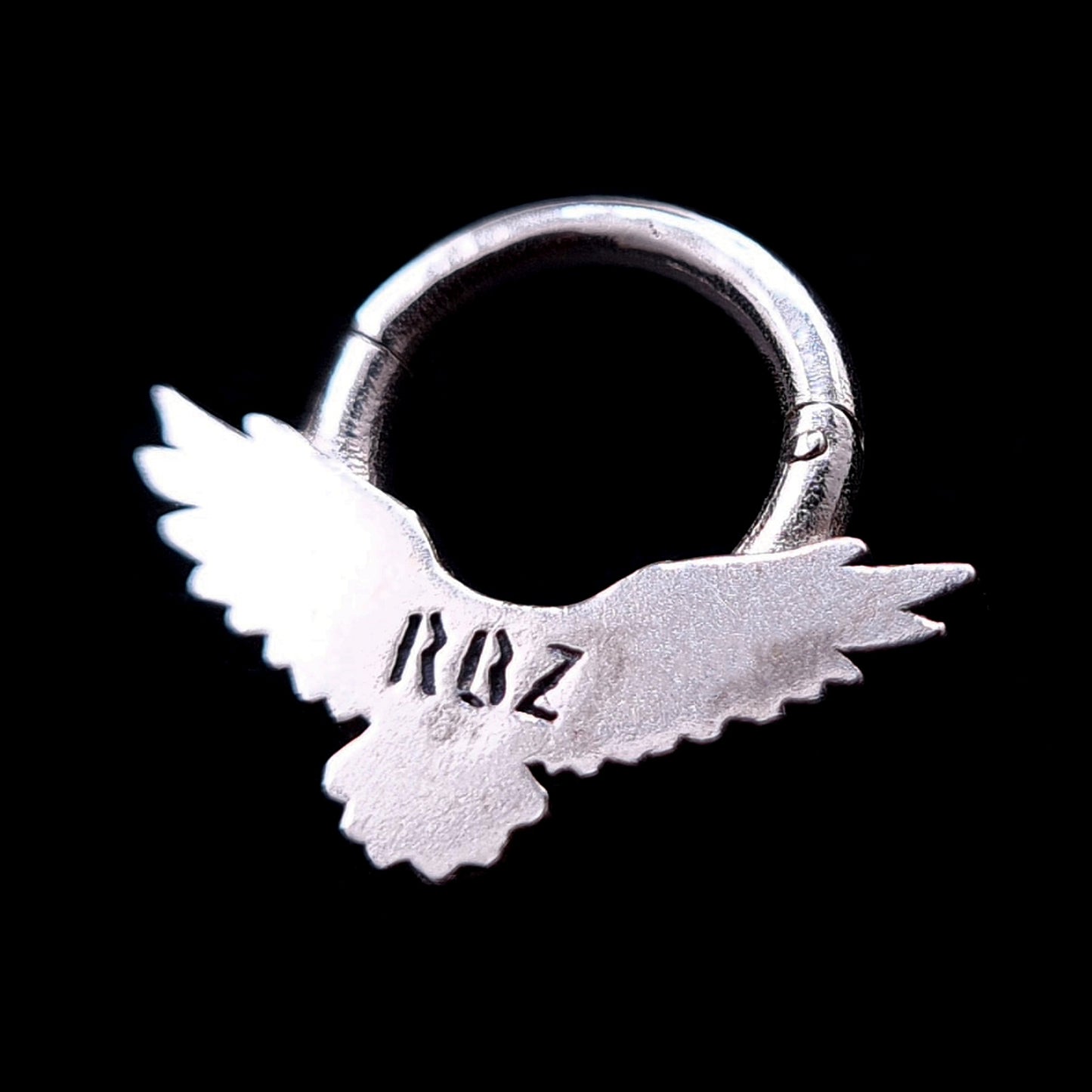 Back view of the Sterling silver Dark Raven septum ring by RBZ Jewelry, showing the brand's RBZ logo engraving and the clicker hinge mechanism against a black background.