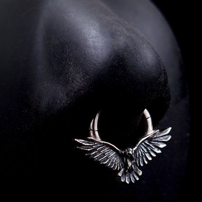 Sterling silver Dark Raven septum ring by RBZ Jewelry shown worn on a life-size black silicone nose model, illustrating the scale and appearance of the Gothic bird design in a realistic piercing placement.