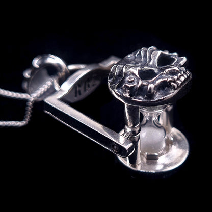 Macro view of the Gothic Rotating Skull Hourglass Pendant in Solid Sterling Silver. Featuring kinetic biomechanical skull caps and a functional sand timer. Handcrafted by RBZ  - Unrestrained Jewelry.