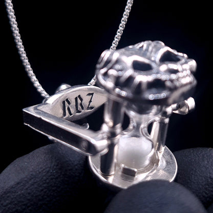 Close-up of the RBZ brand logo engraved on the silver frame of the Rotating Skull Hourglass Pendant. Handcrafted in Solid 925 Sterling Silver by Roy Ben-Ze'ev at RBZ - Unrestrained Jewelry.