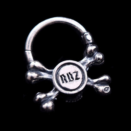Back view of the sterling silver crossbones septum ring by RBZ Jewelry, showcasing the official RBZ maker's mark engraved in a gothic font on the reverse of the oxidized skull.