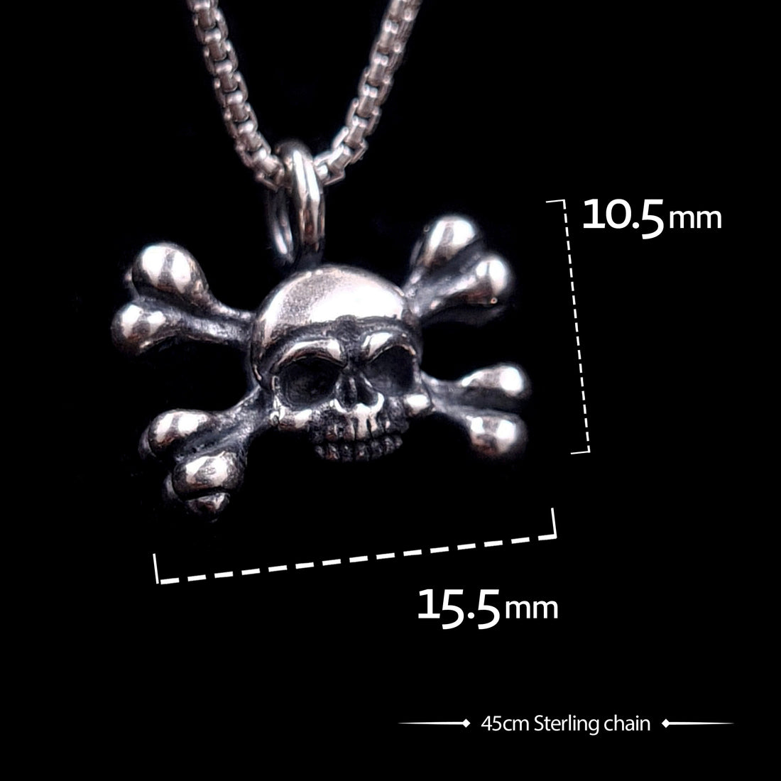 Sterling silver Gothic skull and crossbones pendant by RBZ Jewelry with graphic dimensions showing 10.5mm height and 15.5mm width, paired with a 45cm sterling silver chain.
