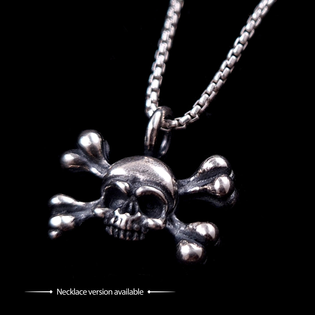 Hand-crafted sterling silver skull and crossbones pendant necklace by RBZ Jewelry, featuring a weathered, oxidized finish and detailed gothic memento mori design on a box chain against a solid black background.