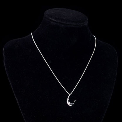 The RBZ Jewelry sterling silver skull jaw pendant displayed on a black mannequin bust to show how it sits on the chest. The detailed gothic mandible charm is suspended from a silver box chain, providing a realistic sense of scale and wearability against a dark, minimalist background.