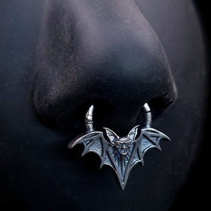 Sterling silver Gothic vampire bat septum clicker ring by RBZ Jewelry, displayed on a life-size black silicone nose model to showcase the fit and detailed oxidized silver finish.