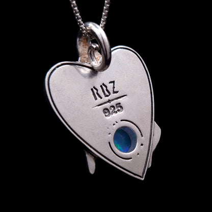 The back of the sterling silver Crystal Ball Witch pendant by RBZ Jewelry, featuring a planchette-shaped flat surface stamped with the RBZ logo and 925 silver hallmark. A circular opening reveals the reverse side of the Ethiopian opal gemstone, showing its play-of-color against a black background.