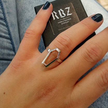 Sterling silver Minimalist Coffin ring by RBZ Jewelry worn by a female model, featuring a hollow geometric frame and architectural Gothic design, shown alongside a branded RBZ - Unrestrained Jewelry gift box.