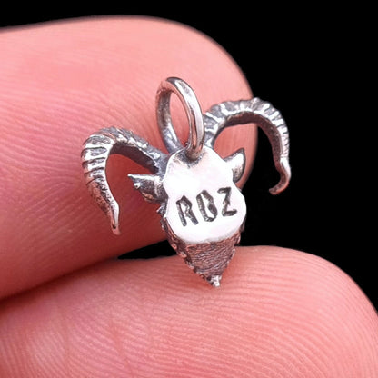 RBZ Jewelry Gothic Sterling Horned Demon pendant rear view held on a finger for scale, showcasing the oxidized sterling silver finish and the stamped RBZ hallmark on the back of the piece.